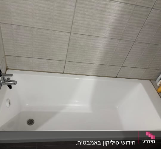 אמבטיה לבנה עם ברז ומוצרים בצד